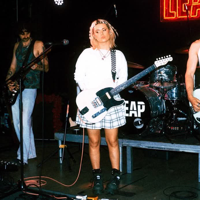 Artist Hana Lili stood holding a guitar