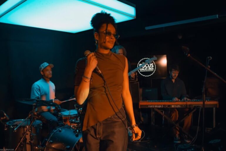 Lily Webbe holding a microphone on a stage