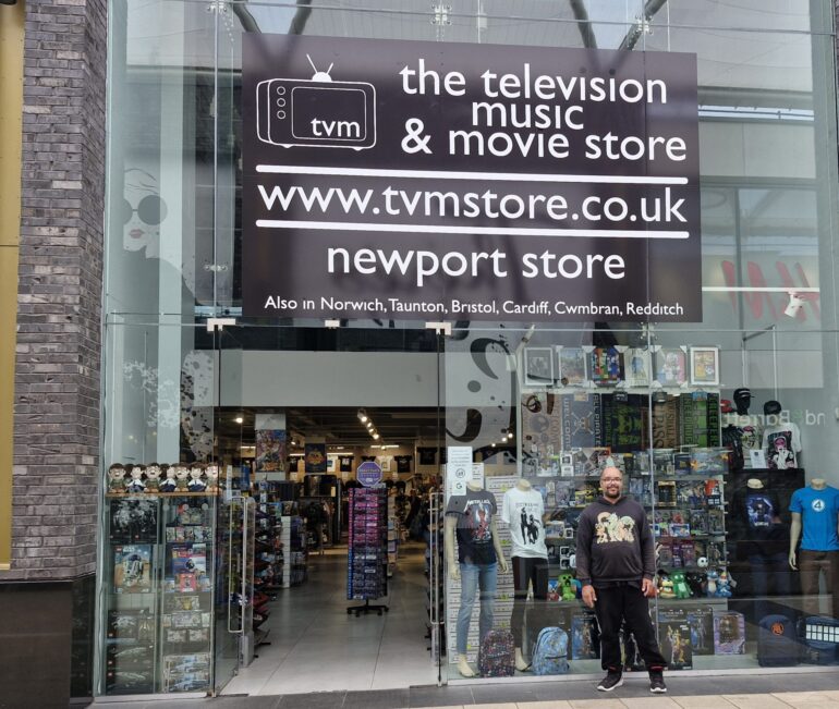 Our volunteer EJ stood outside the new Tv Music and Movie store