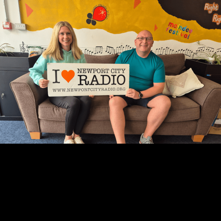 Lamsie sat on sofa with Laura from Newport West Netball